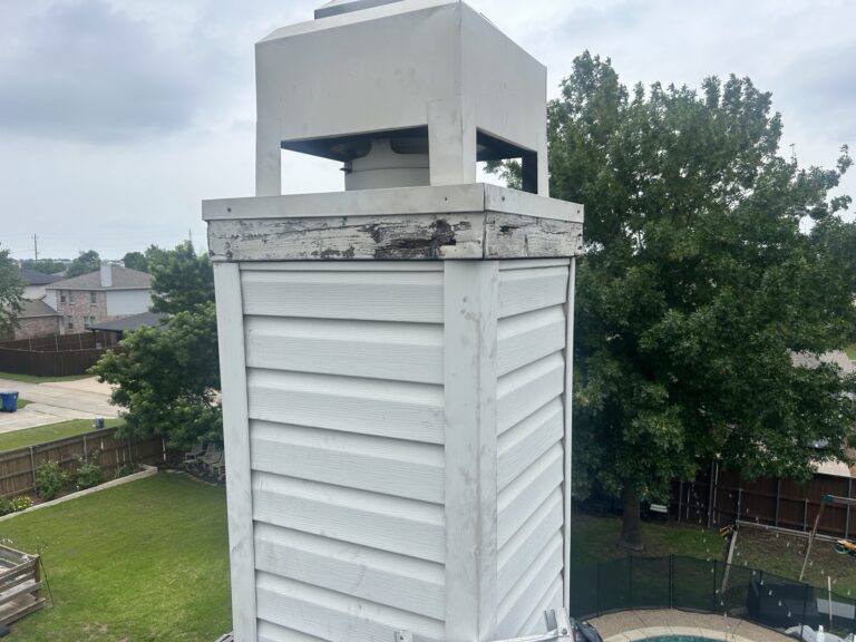 Rotted wood band under the chimney cap, soft from years of water, Dallas TX